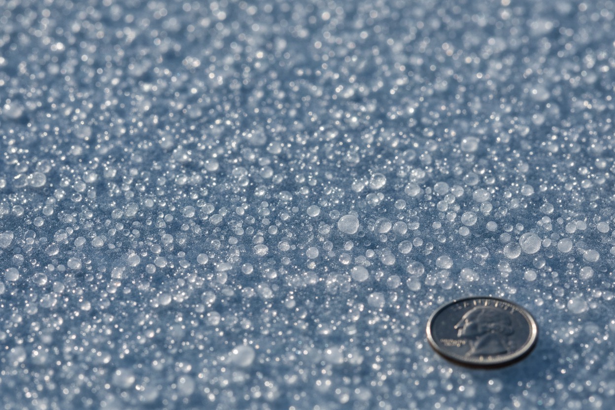 Close-up of pebbled ice texture that brooms melt to change a curling stone's path